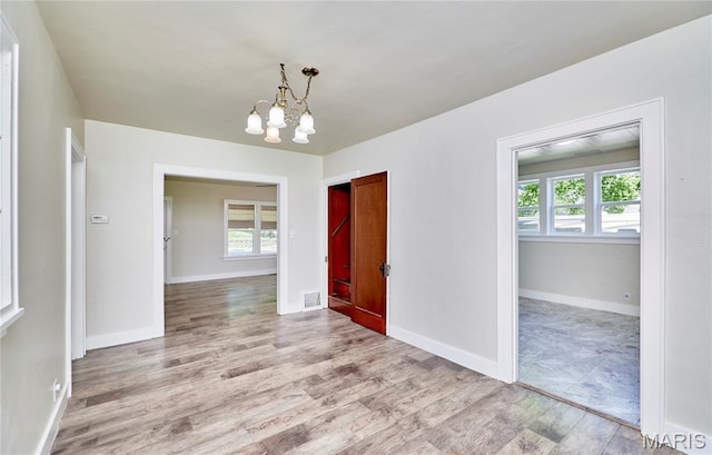 900 3rd St, Troy, MO 63379 - unfurnished room featuring wood finished floors, plenty of natural light, and a chandelier