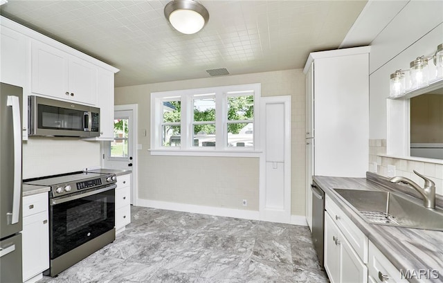 900 3rd St, Troy, MO 63379 - kitchen featuring appliances with stainless steel finishes, tasteful backsplash, white cabinets, and light countertops