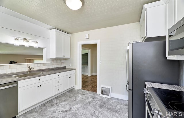 900 3rd St, Troy, MO 63379 - kitchen with appliances with stainless steel finishes, white cabinetry, backsplash, and dark countertops