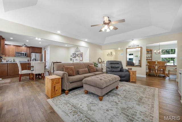 7 Mcclay Village Cir, Saint Peters, MO 63376 - living room featuring a raised ceiling, wood-type flooring, a chandelier, ceiling fan, and recessed lighting