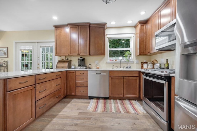 7 Mcclay Village Cir, Saint Peters, MO 63376 - kitchen with stainless steel appliances, light wood-style floors, brown cabinetry, recessed lighting, and a peninsula
