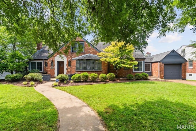7248 Dorset Ave, University City, MO 63130 - english style home with brick siding, a garage, a front yard, and driveway