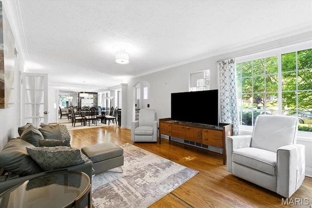 7248 Dorset Ave, University City, MO 63130 - living room featuring arched walkways, plenty of natural light, crown molding, wood finished floors, and a textured ceiling