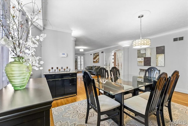7248 Dorset Ave, University City, MO 63130 - dining area with arched walkways, ornamental molding, and light wood-type flooring