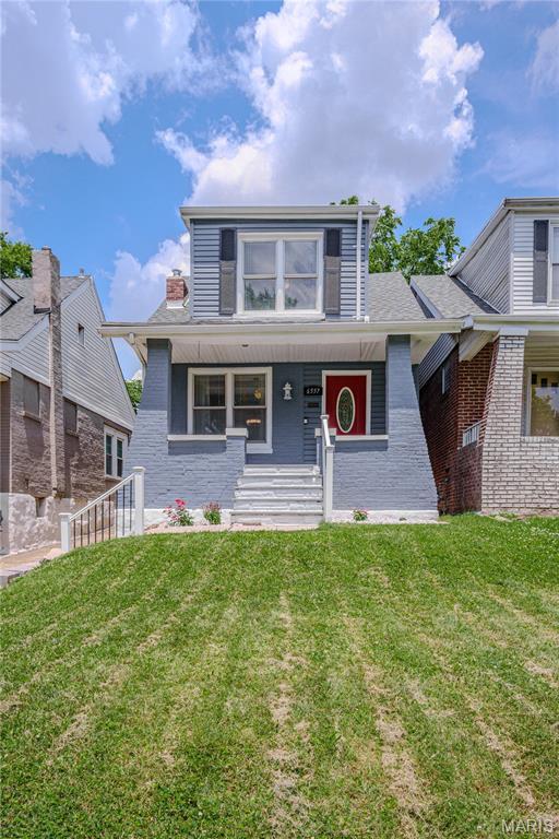 6557 Marmaduke Ave, Saint Louis, MO 63139 - bungalow-style home featuring a front lawn and covered porch