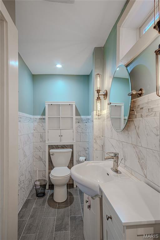 6557 Marmaduke Ave, Saint Louis, MO 63139 - bathroom featuring tile walls, vanity, and wainscoting