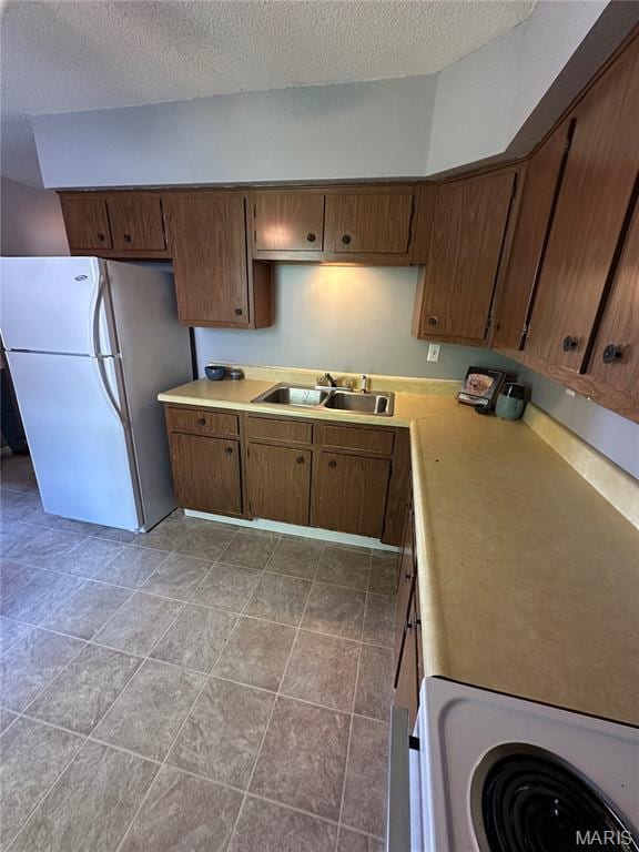 325 N Prairie St, Greenville, IL 62246 - kitchen with freestanding refrigerator, a textured ceiling, light countertops, and range