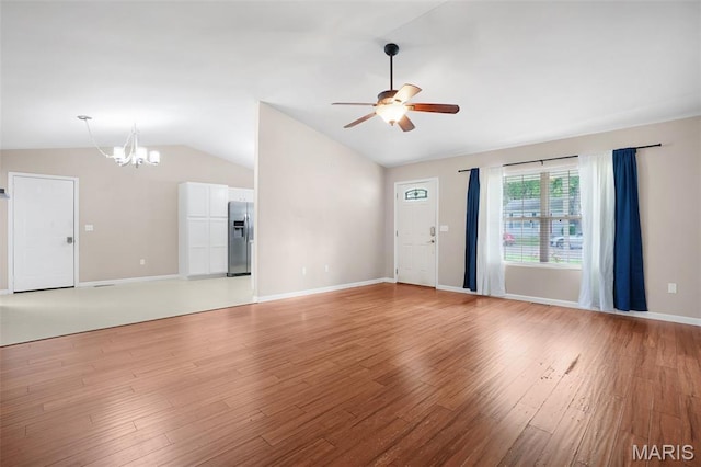 1222 W 8th St, Washington, MO 63090 - unfurnished living room with vaulted ceiling, ceiling fan, a chandelier, and light wood-style floors