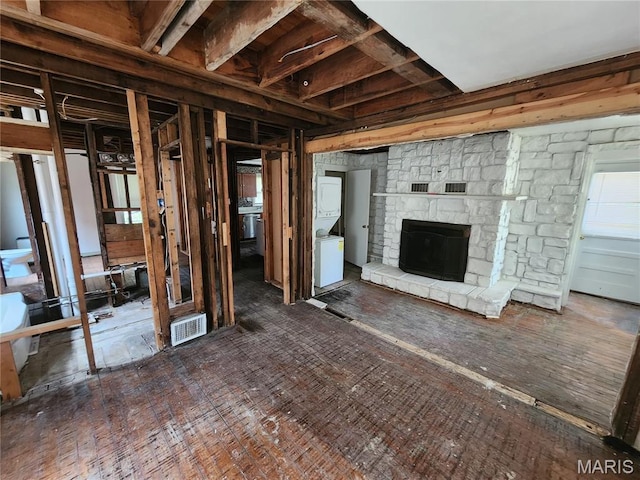3309 Calvert Ave, Breckenridge Hills, MO 63114 - unfurnished living room featuring stacked washer / drying machine and a stone fireplace