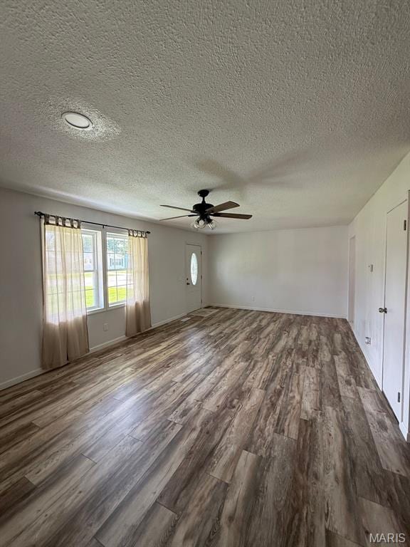 804 W Bain St, Dexter, MO 63841 - unfurnished living room featuring dark wood-type flooring, a textured ceiling, and a ceiling fan