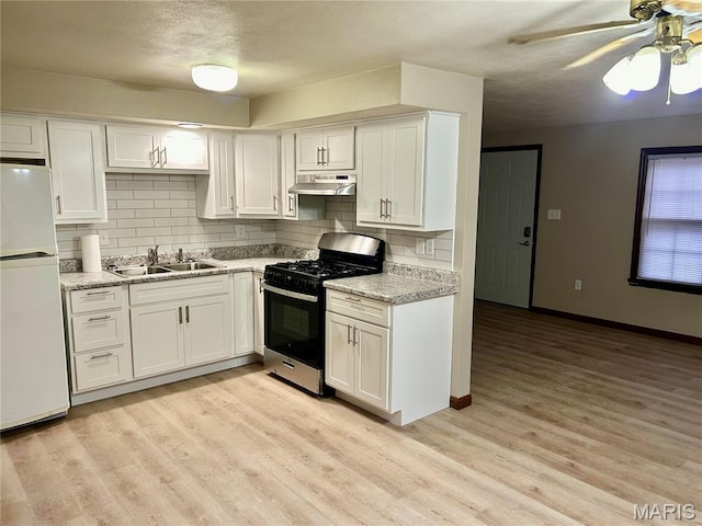 76 Cheshire Dr, Belleville, IL 62223 - kitchen with range with gas cooktop, freestanding refrigerator, under cabinet range hood, a ceiling fan, and white cabinets