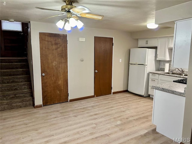 76 Cheshire Dr, Belleville, IL 62223 - kitchen with freestanding refrigerator, light wood-style flooring, white cabinetry, and ceiling fan
