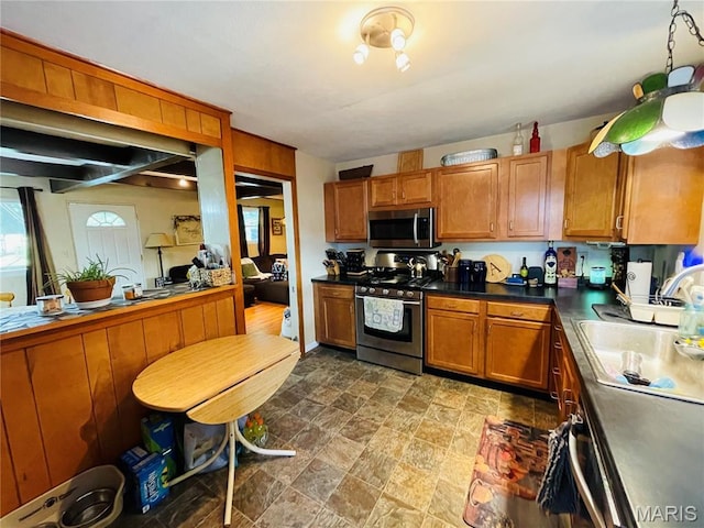 15315 Humbert Rd, Brighton, IL 62012 - kitchen featuring appliances with stainless steel finishes, brown cabinetry, stone finish flooring, and dark countertops