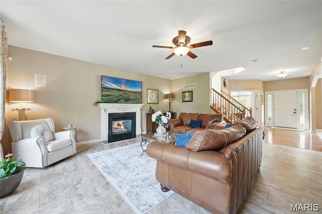 27 Carlton Lake Ct, Wentzville, MO 63385 - living room with a ceiling fan, a glass covered fireplace, and stairs