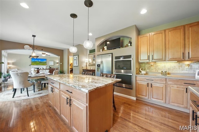 27 Carlton Lake Ct, Wentzville, MO 63385 - kitchen featuring appliances with stainless steel finishes, light wood-type flooring, a center island, light brown cabinets, and recessed lighting