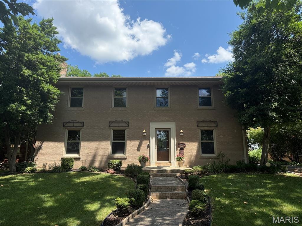 7337 Teasdale Ave, Saint Louis, MO 63130 - colonial inspired home featuring a front yard and brick siding