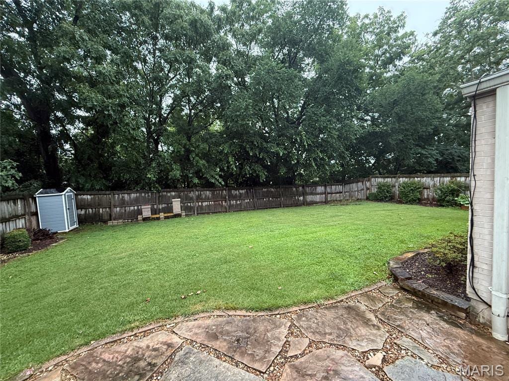 7337 Teasdale Ave, Saint Louis, MO 63130 - fenced backyard with a patio and a storage unit