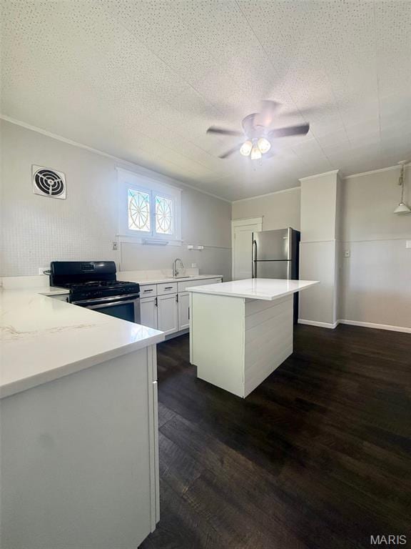 4707 Primm St, Saint Louis, MO 63116 - kitchen featuring black gas stove, freestanding refrigerator, dark wood finished floors, ceiling fan, and white cabinetry