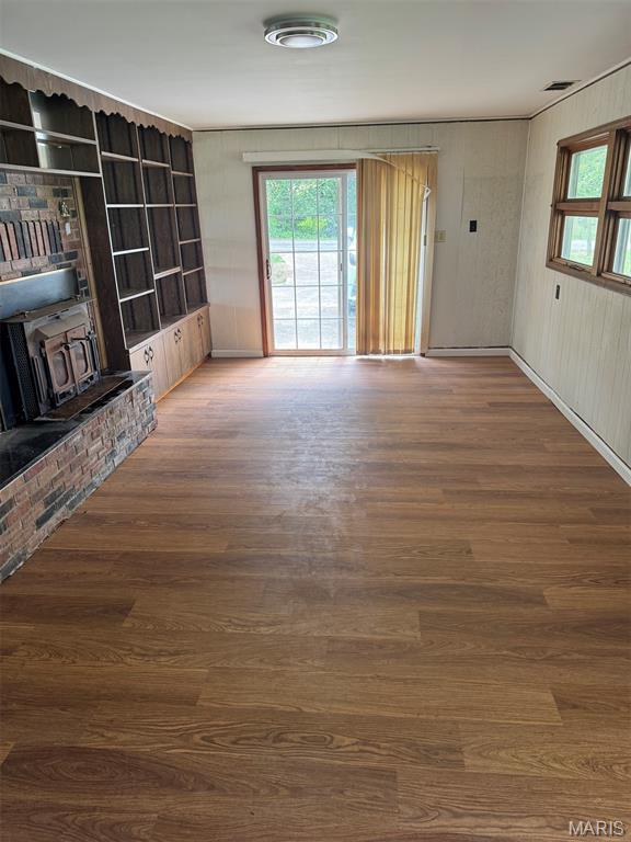 48 E N Ave, Ellsinore, MO 63937 - unfurnished living room featuring a wood stove and wood finished floors
