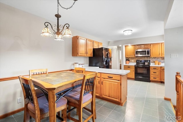 8822 Crest Oak Ln, Saint Louis, MO 63126 - kitchen featuring black appliances, a peninsula, decorative backsplash, light countertops, and a chandelier