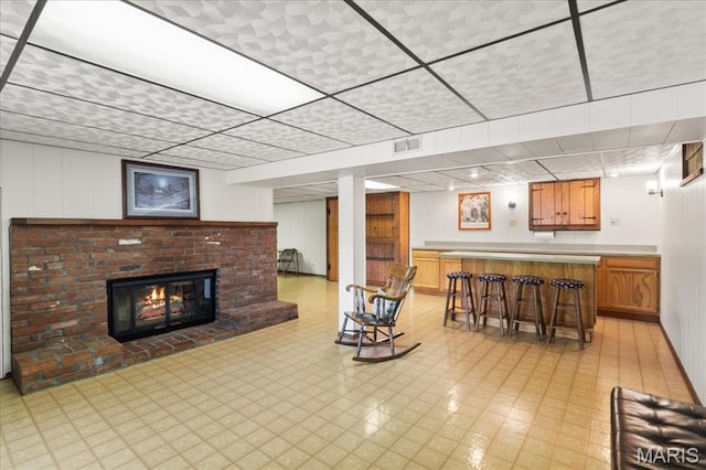 8822 Crest Oak Ln, Saint Louis, MO 63126 - living area with a drop ceiling, bar, light floors, and a brick fireplace