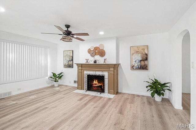 407 N 28th St, Belleville, IL 62226 - living area with arched walkways, wood finished floors, a fireplace with flush hearth, a ceiling fan, and recessed lighting