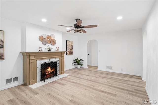 407 N 28th St, Belleville, IL 62226 - unfurnished living room featuring arched walkways, a fireplace with flush hearth, light wood finished floors, recessed lighting, and ceiling fan