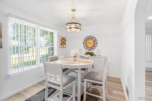 407 N 28th St, Belleville, IL 62226 - dining area with light wood-style flooring, arched walkways, and a chandelier