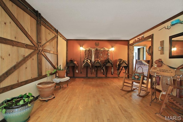31337 Hudson Rd, Lebanon, MO 65536 - interior space featuring light wood-type flooring, crown molding, and a barn door