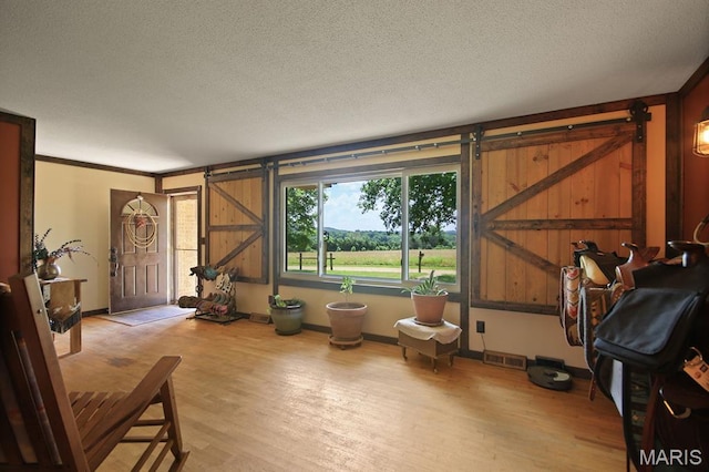 31337 Hudson Rd, Lebanon, MO 65536 - sitting room with a barn door, wood finished floors, and a textured ceiling