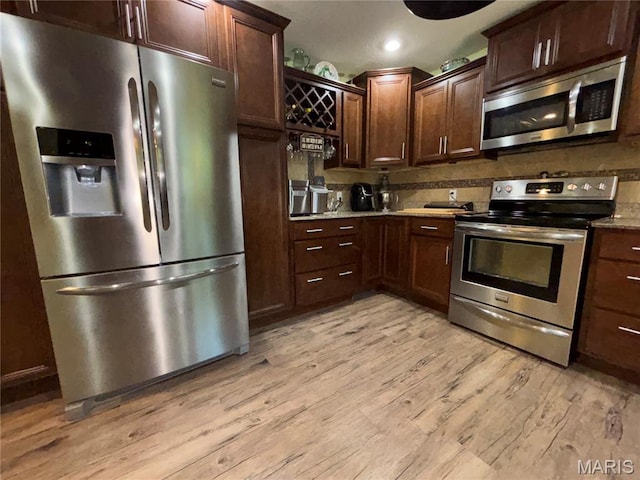208 E Main St, Iberia, MO 65486 - kitchen featuring stainless steel appliances, light wood-style floors, dark brown cabinets, recessed lighting, and light stone countertops