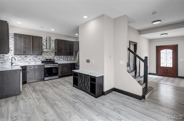 5123 Wicklow Pl, Saint Louis, MO 63111 - kitchen featuring stainless steel gas stove, wall chimney exhaust hood, light countertops, light wood-type flooring, and recessed lighting
