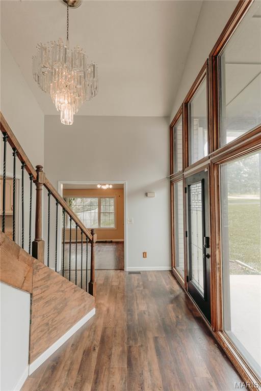 20055 Simmons Rd, Waynesville, MO 65583 - foyer with a chandelier, wood finished floors, stairs, and a towering ceiling