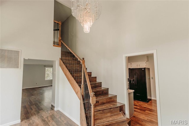 20055 Simmons Rd, Waynesville, MO 65583 - stairs with a towering ceiling, a chandelier, and wood finished floors