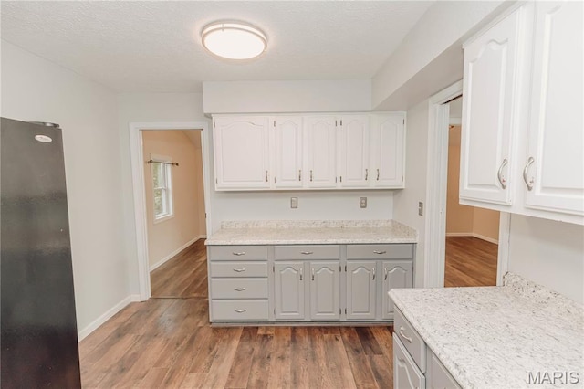 20055 Simmons Rd, Waynesville, MO 65583 - kitchen featuring freestanding refrigerator, gray cabinets, dark wood-type flooring, light countertops, and white cabinets