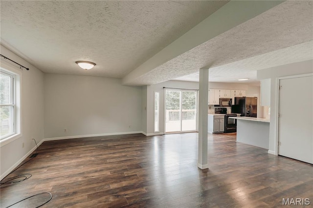 20055 Simmons Rd, Waynesville, MO 65583 - unfurnished living room featuring a textured ceiling and dark wood finished floors
