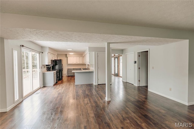20055 Simmons Rd, Waynesville, MO 65583 - kitchen with a textured ceiling, open floor plan, light countertops, freestanding refrigerator, and dark wood-type flooring