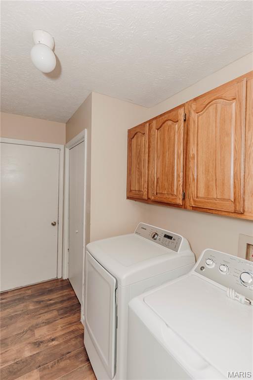 20055 Simmons Rd, Waynesville, MO 65583 - washroom with independent washer and dryer, cabinet space, wood finished floors, and a textured ceiling