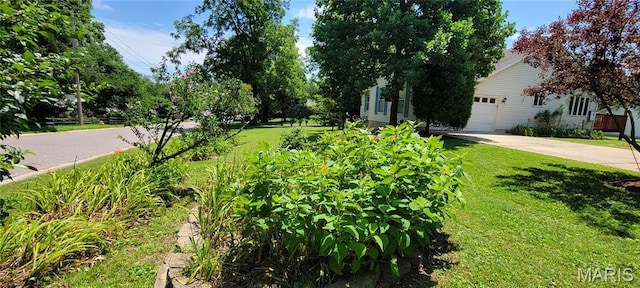 11112 Morrow Dr, Saint Ann, MO 63074 - view of green lawn featuring concrete driveway and an attached garage