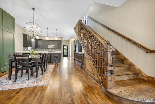 909 S 4th St, Saint Charles, MO 63301 - dining space with stairs, a chandelier, and wood finished floors