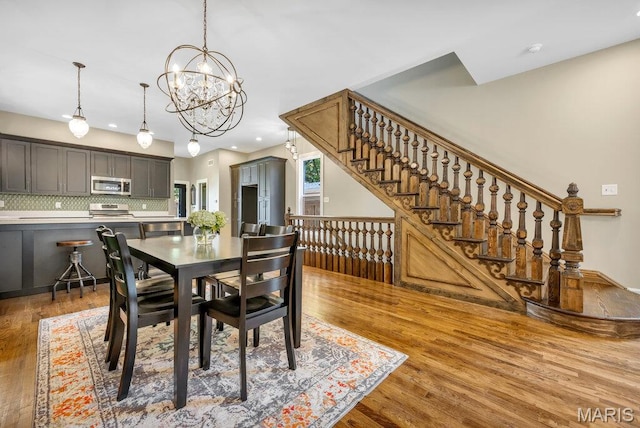 909 S 4th St, Saint Charles, MO 63301 - dining space featuring wood finished floors, stairs, a chandelier, and recessed lighting