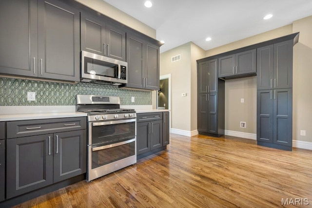 909 S 4th St, Saint Charles, MO 63301 - kitchen featuring appliances with stainless steel finishes, backsplash, light wood-type flooring, light countertops, and recessed lighting