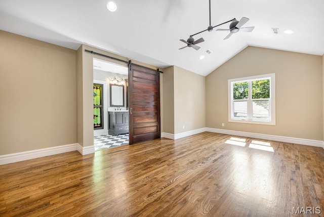 909 S 4th St, Saint Charles, MO 63301 - empty room with a ceiling fan, wood finished floors, a barn door, lofted ceiling, and recessed lighting
