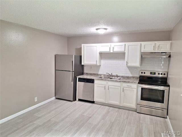 2465 Stoney End Ct, Florissant, MO 63031 - kitchen with appliances with stainless steel finishes, under cabinet range hood, decorative backsplash, white cabinetry, and light wood-type flooring