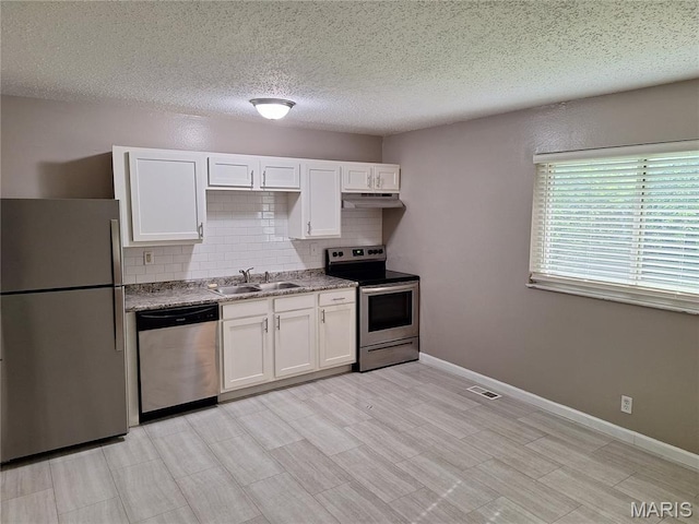2465 Stoney End Ct, Florissant, MO 63031 - kitchen featuring stainless steel appliances, under cabinet range hood, white cabinetry, decorative backsplash, and a textured ceiling