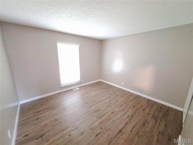 2465 Stoney End Ct, Florissant, MO 63031 - spare room featuring a textured ceiling and wood finished floors