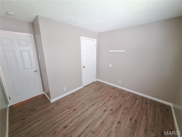2465 Stoney End Ct, Florissant, MO 63031 - unfurnished bedroom featuring wood finished floors, a textured ceiling, and a closet