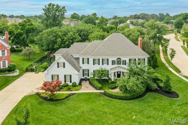 14703 Kulkarni Ct, Chesterfield, MO 63017 - view of front of home with roof with shingles, a front lawn, a chimney, and view of wooded area