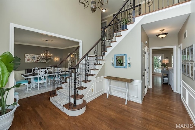 14703 Kulkarni Ct, Chesterfield, MO 63017 - stairway featuring a chandelier, a decorative wall, crown molding, wood finished floors, and a high ceiling