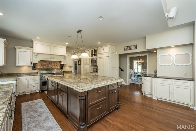 14703 Kulkarni Ct, Chesterfield, MO 63017 - kitchen with high end stainless steel range oven, a chandelier, dark brown cabinets, dark wood-style floors, and light stone countertops